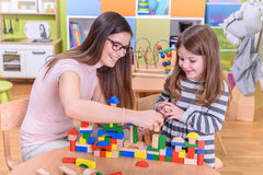 happy kid young teacher playing kindergarten toy blocks 62488564